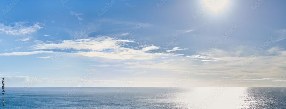 Copy space at sea with the sun in a clear blue sky in the background. Calm ocean tide in an open ocean. A scenic seascape for a relaxing summer holiday with cloudy sky and clean water on the coast