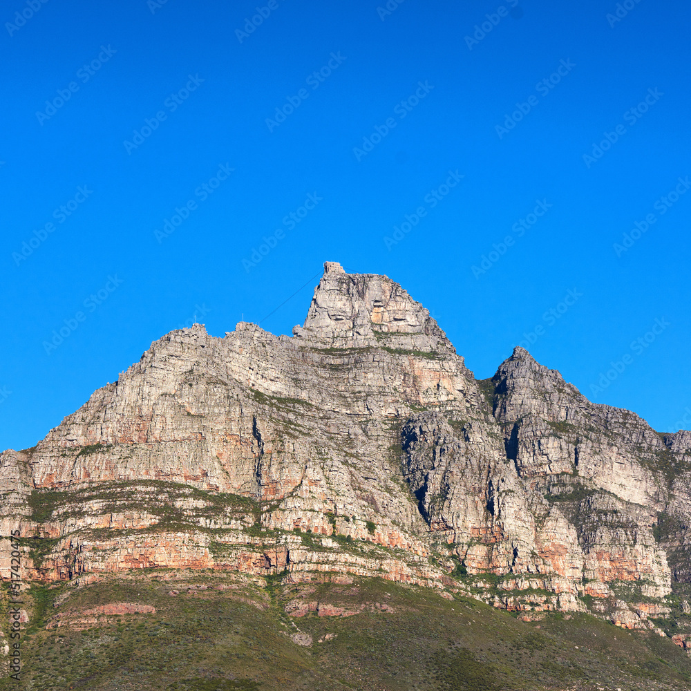 A scenic landscape view of Table Mountain in Cape Town, South Africa against a blue sky background from below. A panoramic view of an iconic landmark and famous travel destination with copyspace