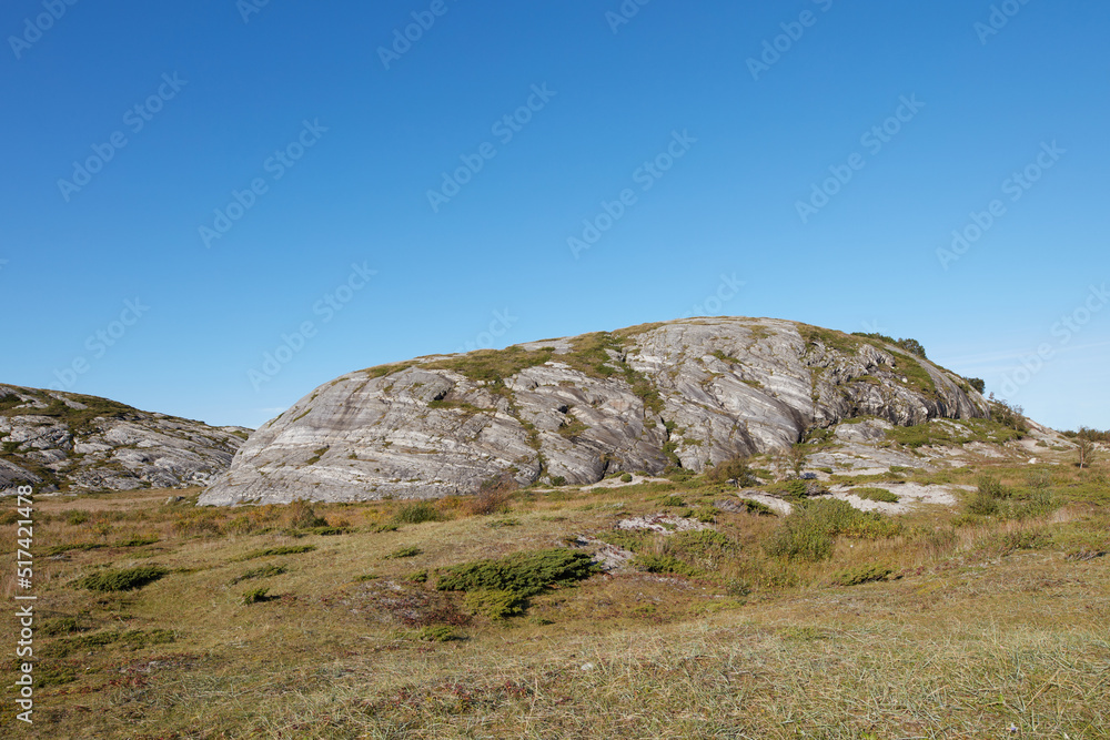 Scenic landscape of Bodo in Nordland with natural surrounding and blue sky copyspace background. Rock formation on mountain and hill with dry barren plants. Hiking trails in the countryside of Norway
