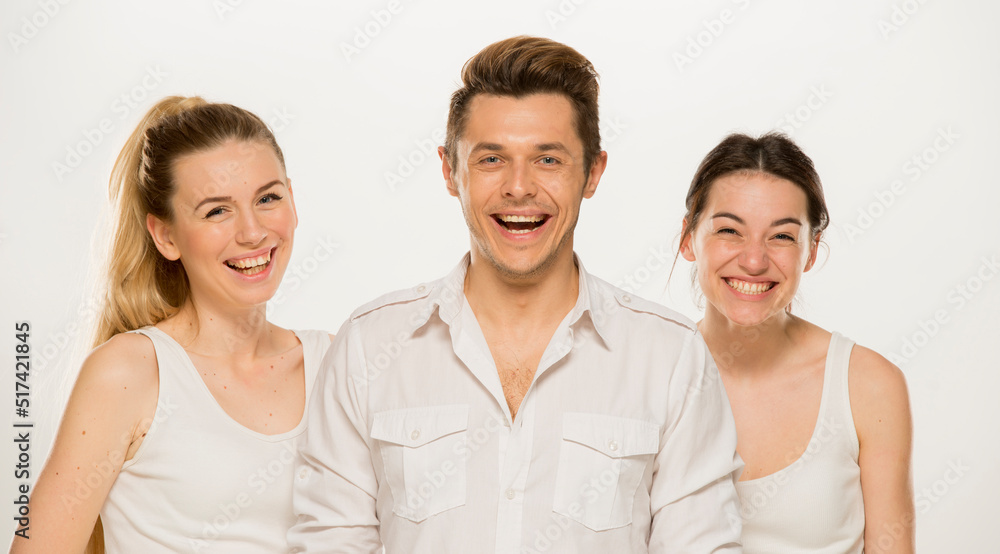 team of young business people in white shirts on a white background isolated. a team of two girls and a guy is happy, wins, plans, argues, discusses, gets upset, wins something. close-up portrait team of young business people in white shirts on a white background isolated. a team of two girls and a guy is happy, wins, plans, argues, discusses, gets upset, wins something. close-up portrait
