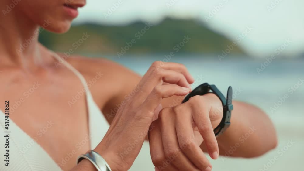 asian woman look at smartwatch at the beach in summer. asian woman look at smartwatch at the beach in summer.