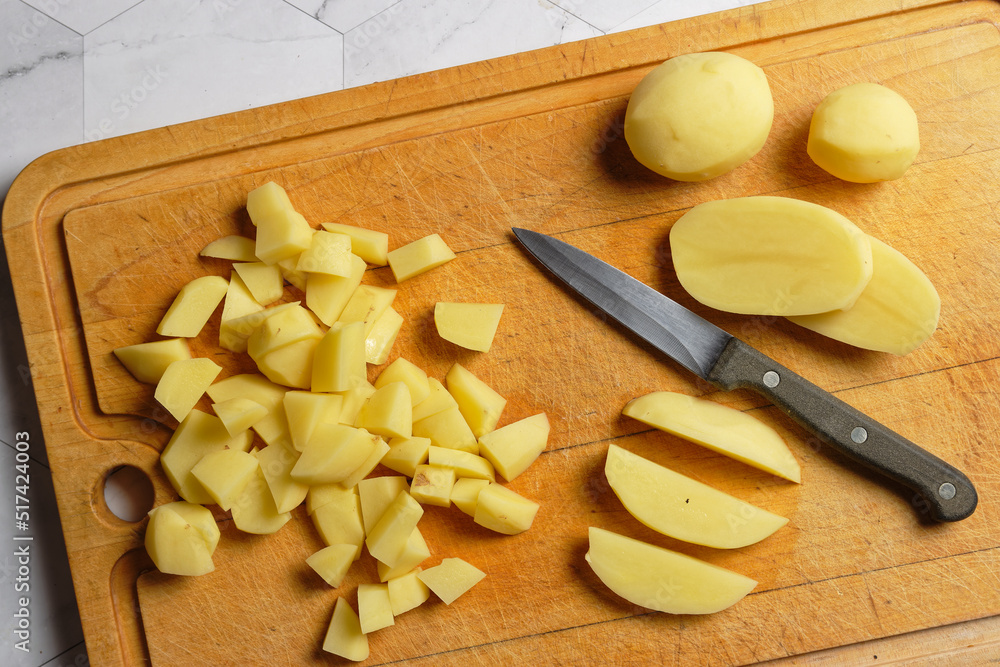Peeled potatoes on a wooden cutting board Peeled potatoes on a wooden cutting board