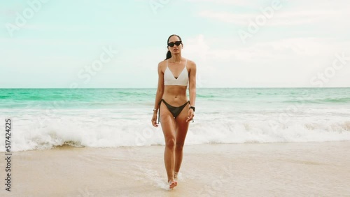 A Sensual Model Asian woman tan skin in bikini walking on the beach