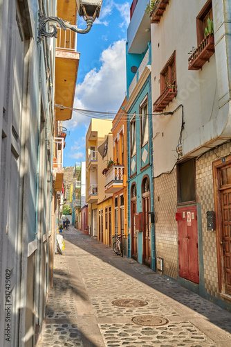 Fototapeta Naklejka Na Ścianę i Meble -  Colorful historic buildings in vibrant city of Santa Cruz de La Palma with cobblestone alleyway on a sunny day. Bright residential houses in a popular village of a travel and tourism destination