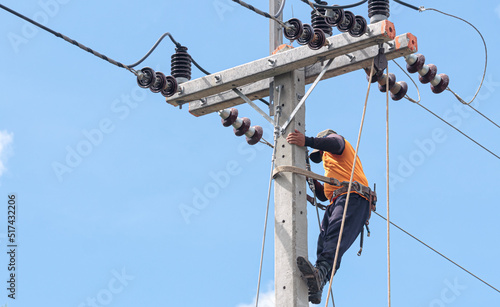 Electrician lineman repairman worker at climbing work on electric post power pole