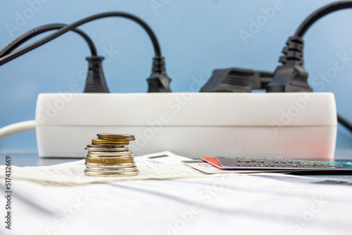 Money, bank credit cards and electricity bills on the background of an electrical outlet. Electricity debts, the concept of rising electricity prices.
