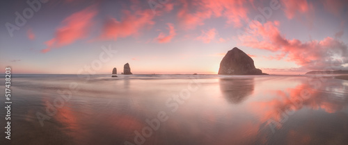The Sunset at Cannon Beach with Dramatic clouds in the background and a nice reflection in water. Dramatic coastal seascape featuring scenic rock formations Haystack Rock Oregon, USA