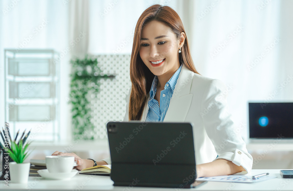 Asian beautiful businesswoman working in the office with a tablet computer for working online video conference concept. Asian beautiful businesswoman working in the office with a tablet computer for working online video conference concept.