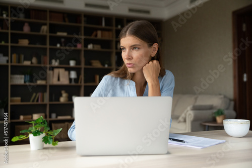 Cuadro en lienzo Young pensive businesslady sit at workplace in modern homeoffice distracted from