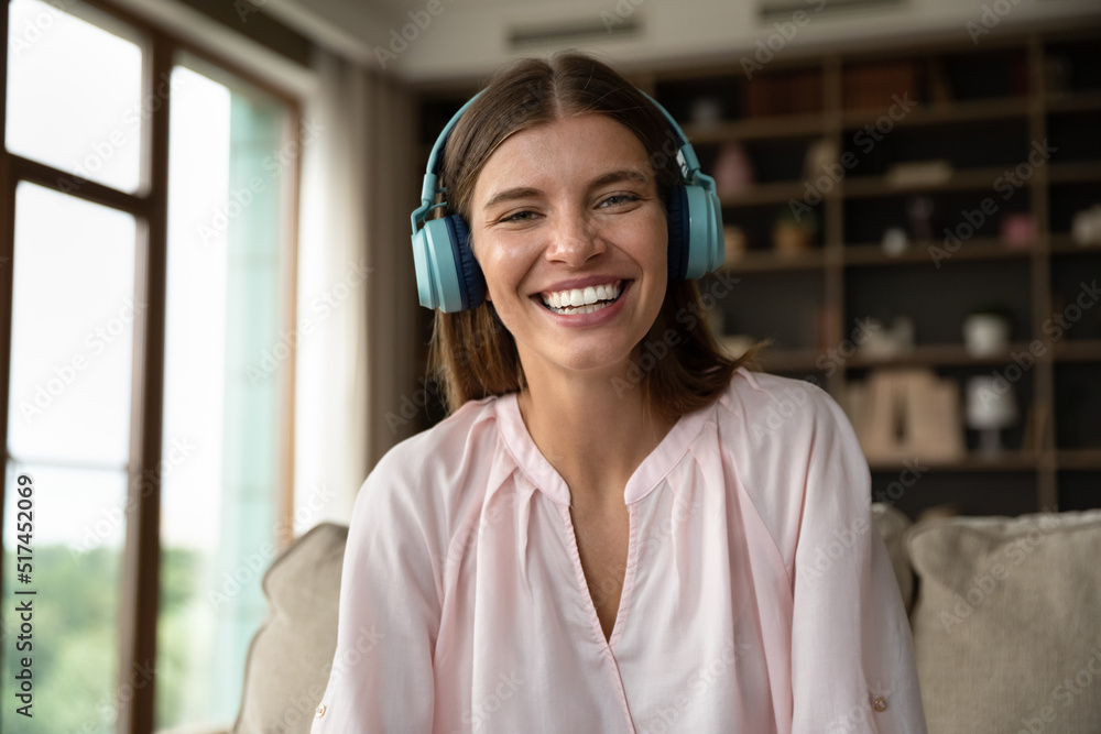 Head shot portrait woman in headphones take part in on-line stream, vlogger record video, enjoy remote conversation via videoconference to family or friend. Modern technology, communication concept
