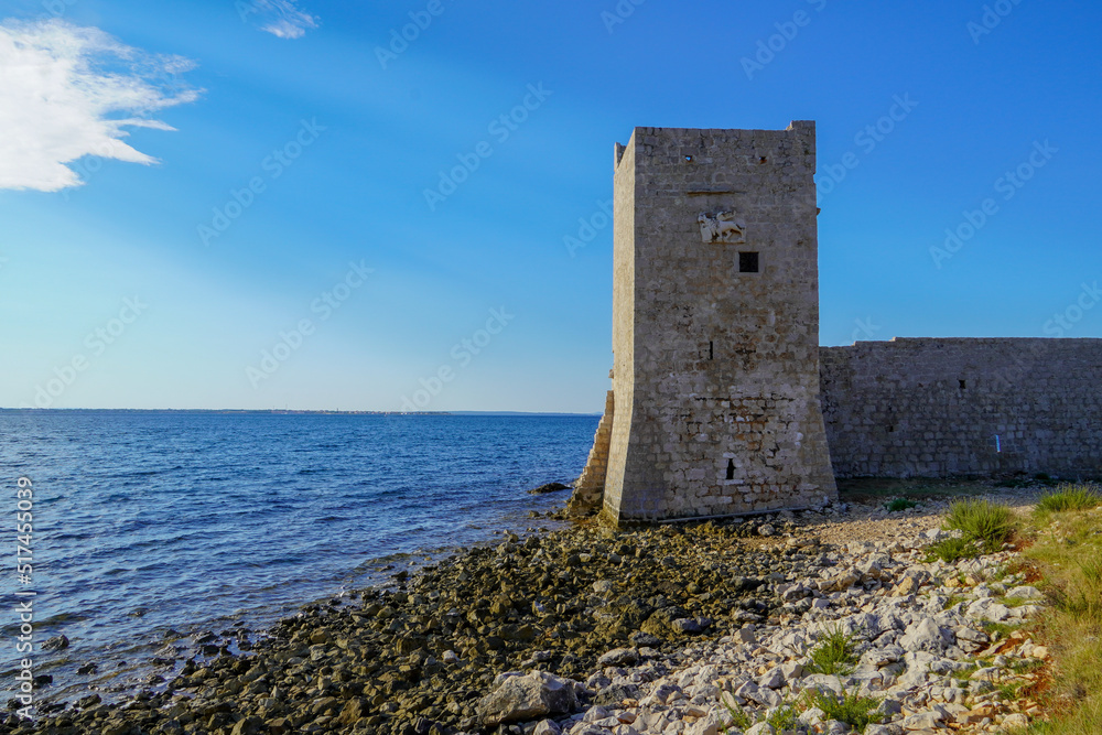 An old stone tower on the beach, in Croatia.
