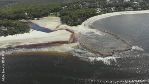 Drone video of Moona Moona Creek and Huskisson beach area after recent flooding with brown dirty water flowing into the bay photo