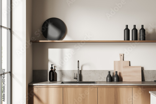 Light kitchen set interior with sink and deck with kitchenware, window