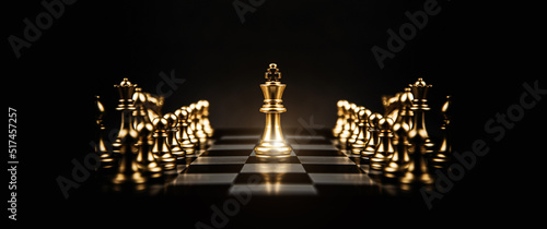 Fotografija King chess piece stand on chessboard concepts of competition challenge of leader business team or teamwork volunteer or wining and leadership strategic plan and risk management or team player