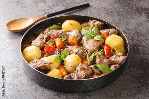 Old traditional dish in Croatia called peka or sac Meat lamb with potatoes and vegetables close-up on the table. horizontal photo