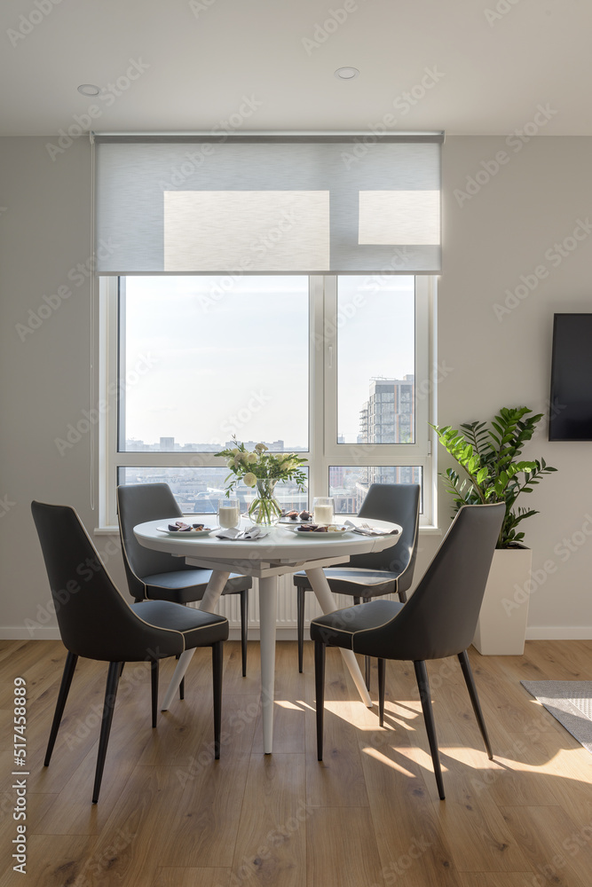 Fototapeta premium modern dining room with table, modern living room with light walls, breakfast in the apartment