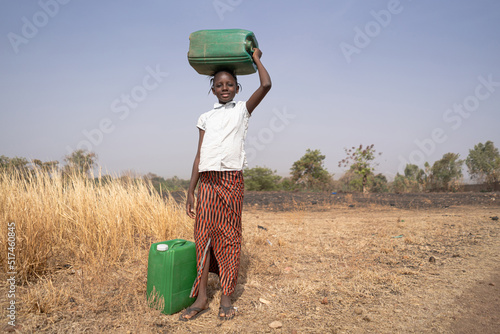 Slika na platnu African girl with green windows in a savanna landscape; lack of water infrastruc