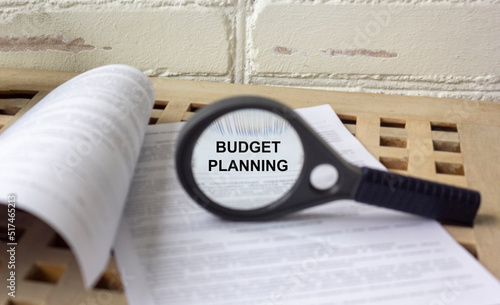 Planning Monthly Budget text through magnifying glass on documents
