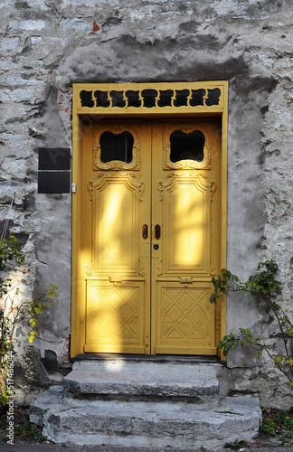 Ancient yellow door on old stone building