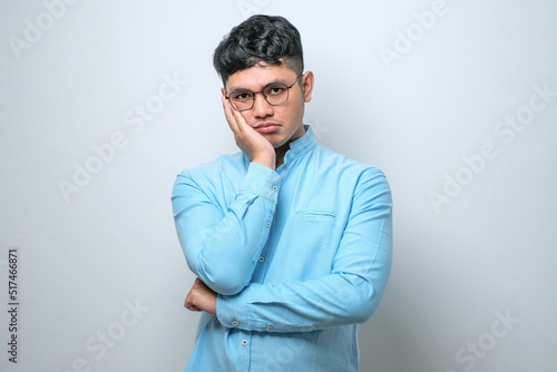 Young asian man thinking looking tired and bored with depression problems with crossed arms.