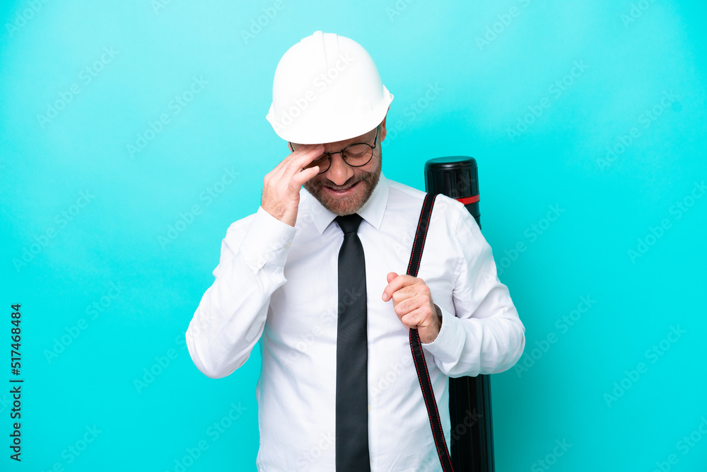 Middle age architect man with helmet and holding blueprints isolated on blue background laughing Middle age architect man with helmet and holding blueprints isolated on blue background laughing