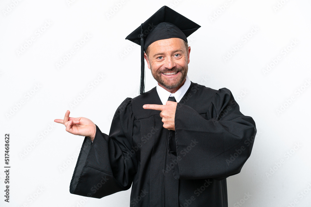 Middle age university graduate man isolated on white background surprised and pointing side Middle age university graduate man isolated on white background surprised and pointing side
