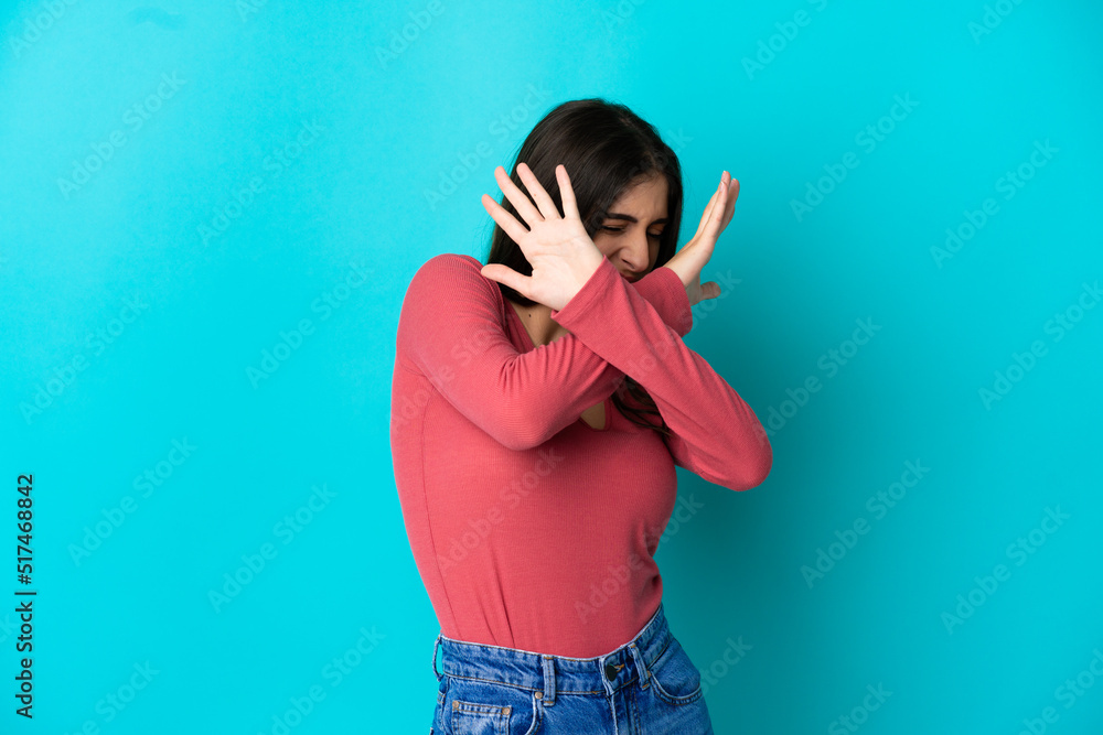 Young caucasian woman isolated on blue background nervous stretching hands to the front Young caucasian woman isolated on blue background nervous stretching hands to the front