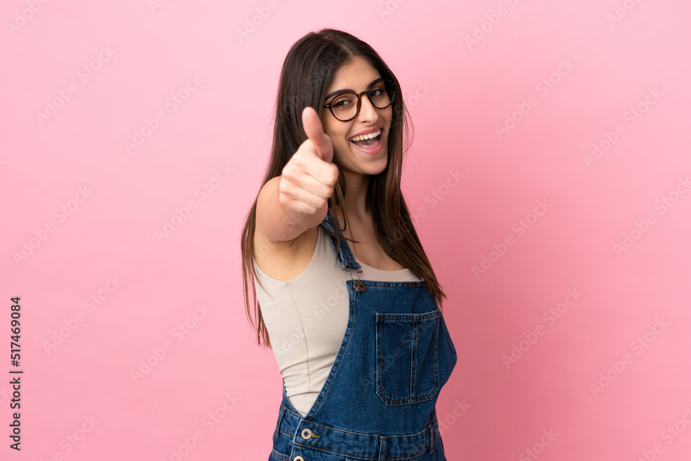 Young caucasian woman isolated on pink background with thumbs up because something good has happened Young caucasian woman isolated on pink background with thumbs up because something good has happened