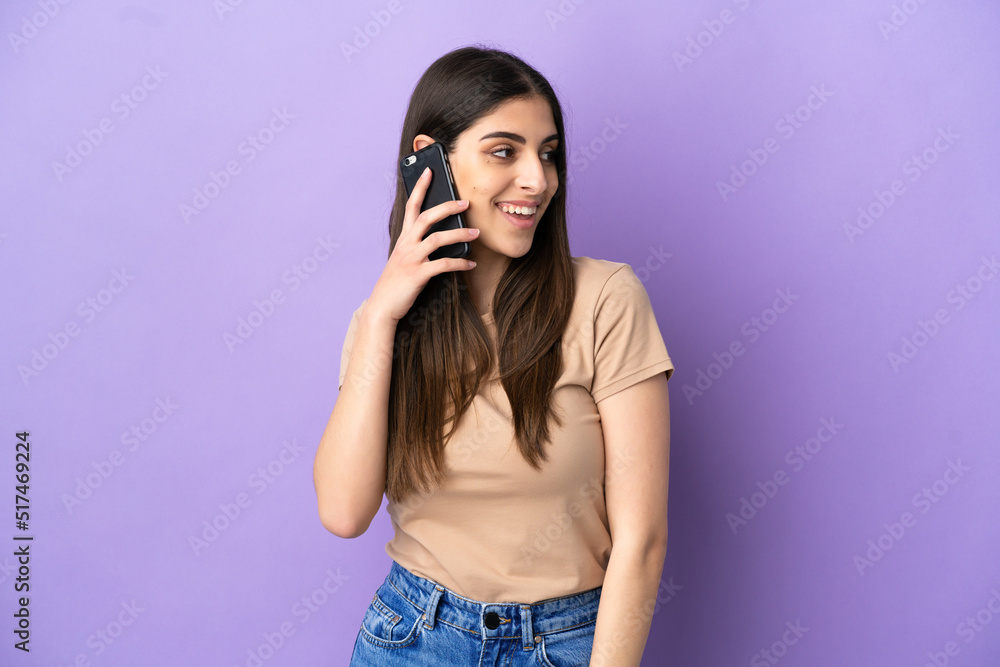 Young caucasian woman using mobile phone isolated on purple background looking side Young caucasian woman using mobile phone isolated on purple background looking side