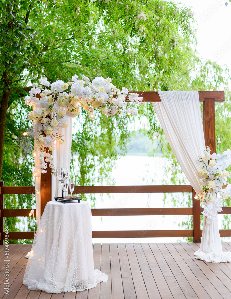 Beautiful summer wedding arch for ceremonies in the forest against the background of the lake Beautiful summer wedding arch for ceremonies in the forest against the background of the lake