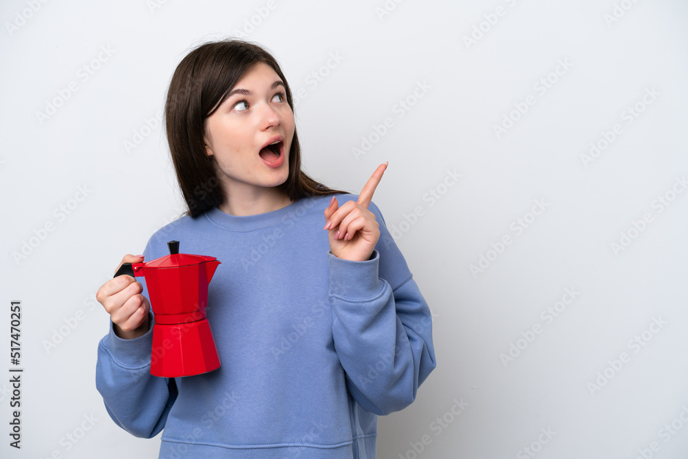 Young Russian woman holding coffee pot isolated on white background intending to realizes the solution while lifting a finger up Young Russian woman holding coffee pot isolated on white background intending to realizes the solution while lifting a finger up