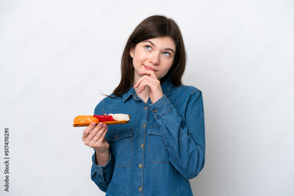 Young Russian woman holding sashimi isolated on white background and looking up
