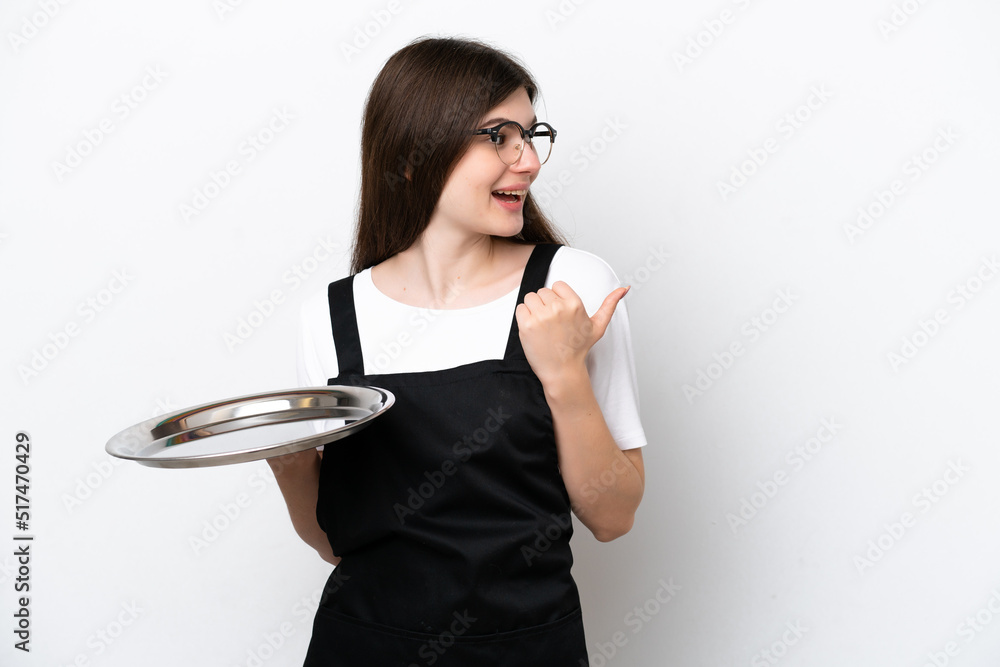 Young Russian woman chef with tray isolated on white background pointing to the side to present a product Young Russian woman chef with tray isolated on white background pointing to the side to present a product