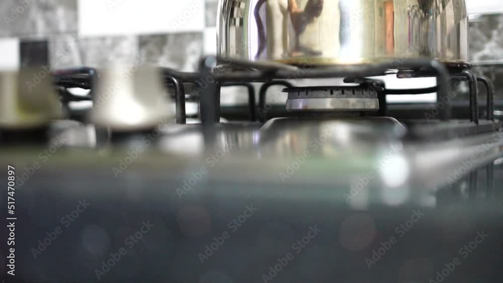 Unrecognizable woman hand turning on stove switch, lighting kitchen