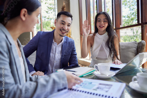 Three diverse business people discussing and planning projects using analytical papers during a meeting in the office. Business and finance concept. Multiracial colleagues checking documents. photo