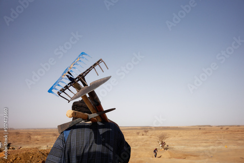 Gold artisanal miner carrying rakes and shovel in the Inchiri desert, Mauritania. photo