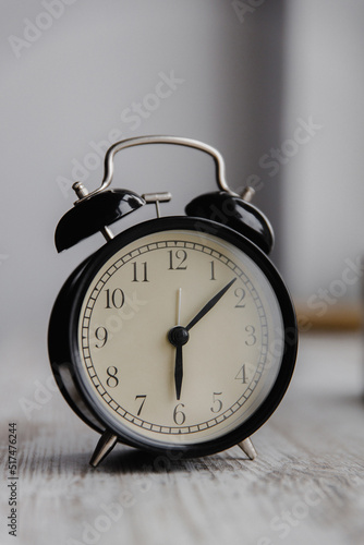 Close-up of a black vintage alarm clock on a light background