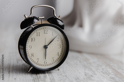 Close-up of a black vintage alarm clock on a light background