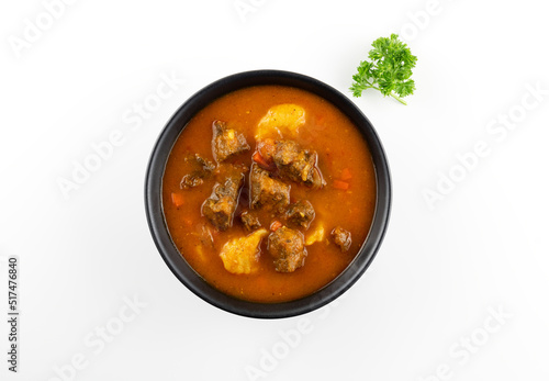 Traditional Hungarian cuisine. Thick Hungarian soup - beef goulash, paprika, carrots and potatoes on a white plate macro..
