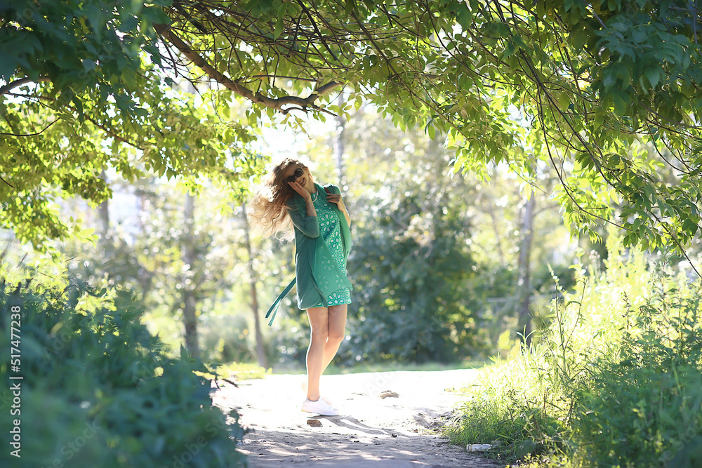 playful adult young girl in summer swirls jumping / cheerful beautiful model in the park, summer look in a short skirt, legs playful adult young girl in summer swirls jumping / cheerful beautiful model in the park, summer look in a short skirt, legs