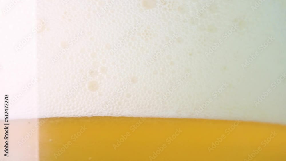 Beer with white foam in a glass spinning round. 4k video in slow motion Beer with white foam in a glass spinning round. 4k video in slow motion