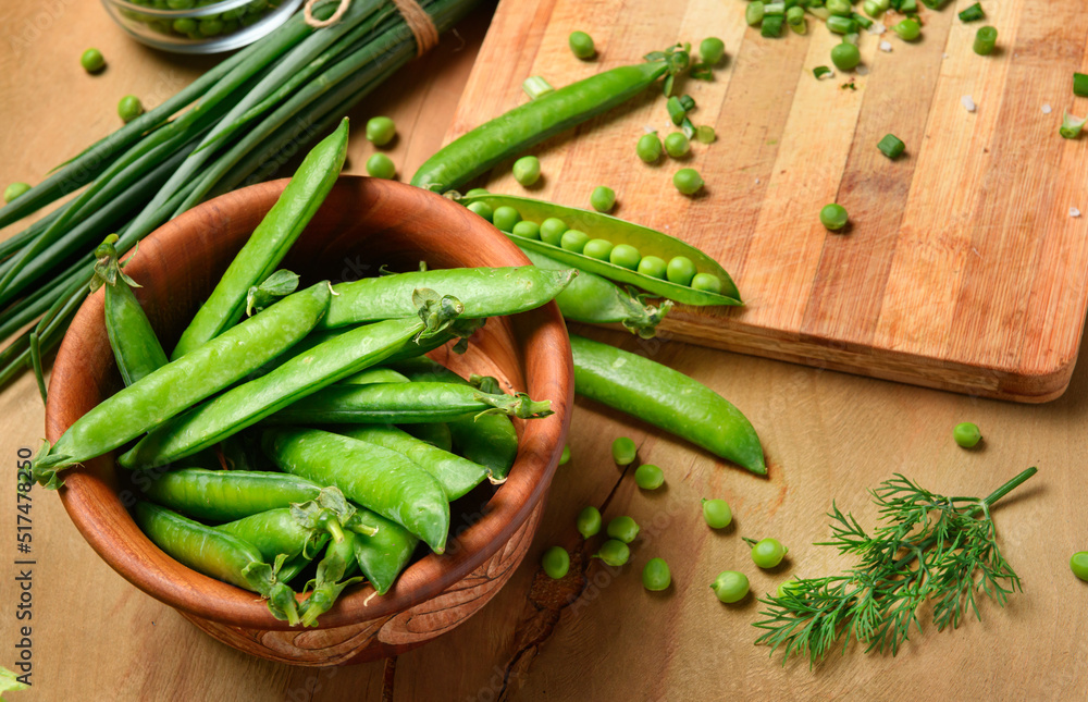 vegetables on a wooden kitchen board, sliced green onions, dill and peas on a wood background, concept of fresh and healthy food, still life vegetables on a wooden kitchen board, sliced green onions, dill and peas on a wood background, concept of fresh and healthy food, still life