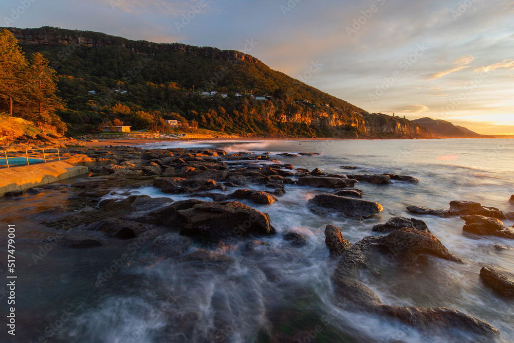 Sunrise view at the rocky beach shore.