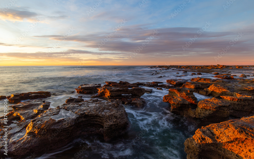 Sunrise view at the rocky beach coastline.