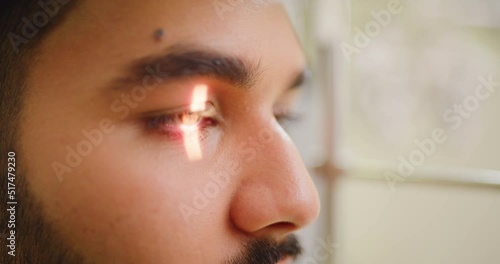 Closeup of a slit lamp machine testing a patients eye or pupil reflex during an optician consult. Headshot of a man visiting optometrist, using LED light to examine astigmatism and retina reflection photo
