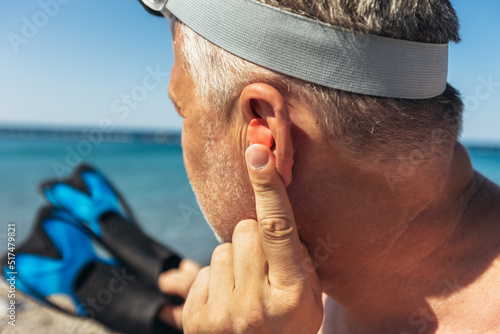 Canvastavla Mature man putting silicone ear plugs, surfers earplugs, swim plugs