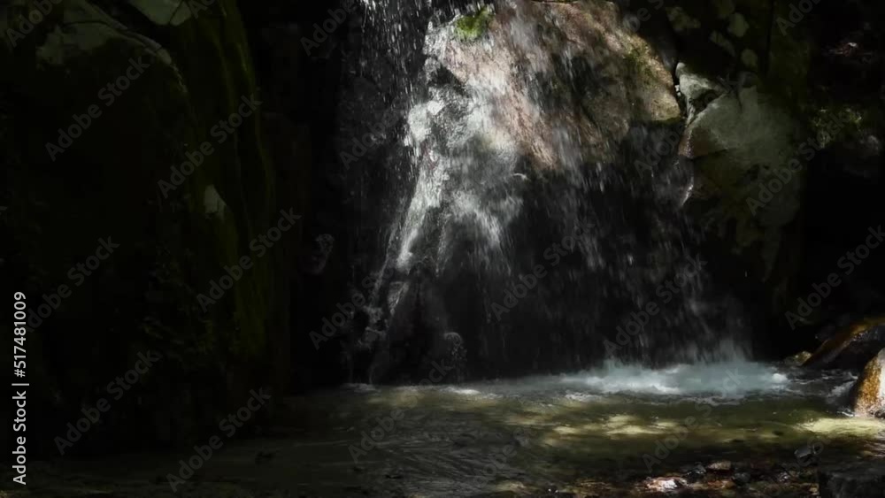 Water from the waterfall passing over rocks and falling into the waterfall basin 2 Water from the waterfall passing over rocks and falling into the waterfall basin 2