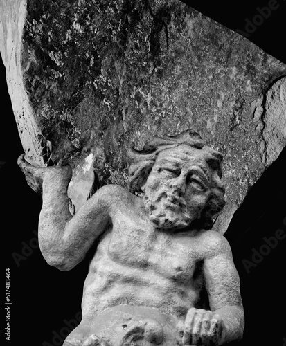Foto Very ancient stone statue of Sisyphus with stone