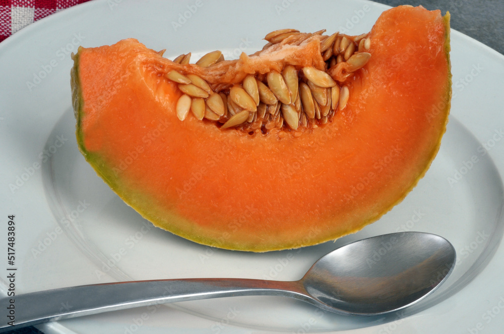 Tranche de melon tranché dans une assiette avec une cuillère Tranche de melon tranché dans une assiette avec une cuillère
