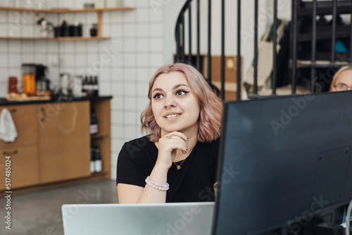 Smiling female entrepreneur with hand on chin at office during meeting photo